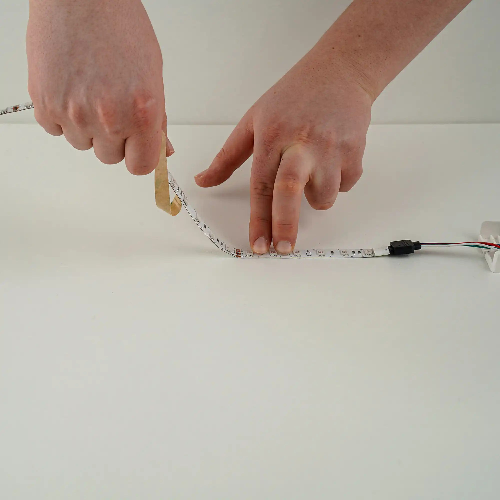 LED-strip bevestigen door de beschermfolie van de plakstrip te verwijderen voor eenvoudige montage