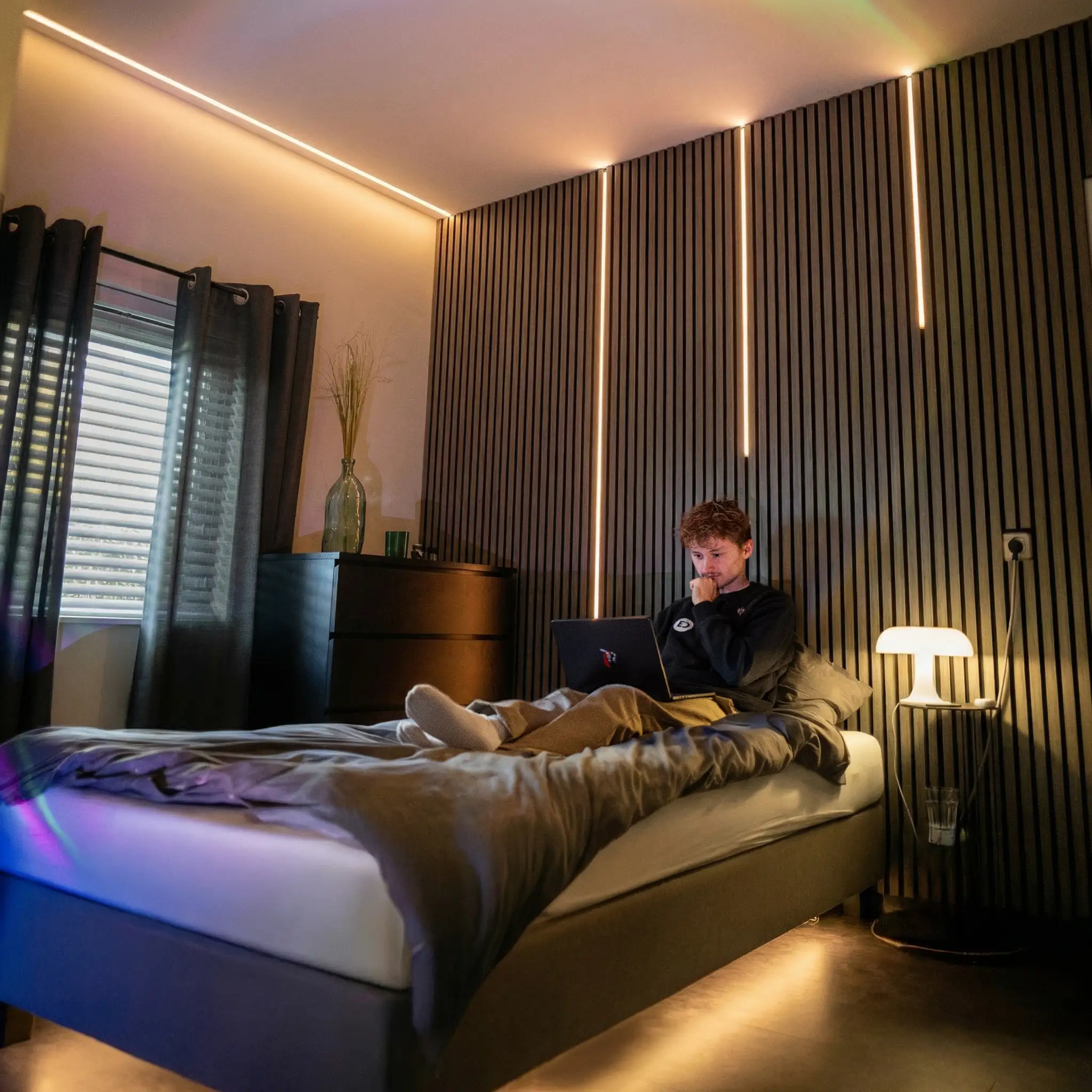 LED-strips en neon strips in een moderne slaapkamer met warme sfeerverlichting langs wand, plafond en bed